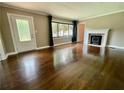 Inviting living room featuring a cozy fireplace, window, and hardwood flooring at 727 Channing Nw Dr, Atlanta, GA 30318