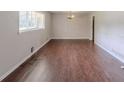 Open living room featuring hardwood floors and natural light from the large window at 29 Parkwood Ne Dr, Kennesaw, GA 30144