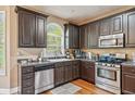 Cozy kitchen featuring stainless steel appliances, granite countertops, and dark wood cabinets at 642 Towering Pine Trl, Lawrenceville, GA 30045