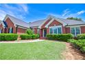 Charming brick home featuring lush green lawn, mature landscaping, and inviting entrance at 811 Ivy Ridge Dr, Loganville, GA 30052