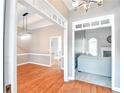 Bright living room with hardwood floors, open doorway, and modern lighting fixtures throughout home at 811 Ivy Ridge Dr, Loganville, GA 30052