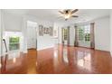 Bright living room featuring hardwood floors, a ceiling fan, and two large windows letting in natural light at 6213 Indian Wood Cir, Mableton, GA 30126