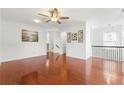 Spacious living room with gleaming hardwood floors, a ceiling fan, and access to the upper level at 6213 Indian Wood Cir, Mableton, GA 30126