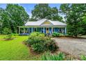 Charming blue home with a metal roof, inviting front porch, and lovely landscaping at 7550 Fielder Rd, Jonesboro, GA 30236
