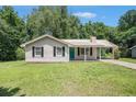 Charming one-story home with a metal roof, teal door, and well-maintained front yard at 10312 Waterford Ne Rd, Covington, GA 30014