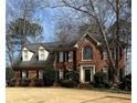 Traditional brick home featuring a large front yard, arched window, and a welcoming entrance at 3580 Treeline Ne Pass, Roswell, GA 30075