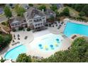 Aerial view of a clubhouse and pool area featuring lush landscaping and various amenities at 221 Village Overlook # H2, Canton, GA 30114