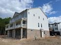 Side view of a new townhouse featuring white siding and a brick foundation at 221 Village Overlook # H2, Canton, GA 30114