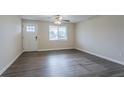 Inviting living room with new wood-look flooring, large window, and a door with window panes at 2290 Pope Rd, Douglasville, GA 30135