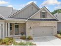 Inviting townhome features a brick facade, covered entrance, and a two-car garage at 2499 Barrett Preserve Sw Ct, Marietta, GA 30064