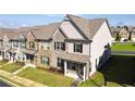 Beautifully landscaped townhome exterior showcasing a well-manicured lawn and cozy front porch at 2692 Pearl Ridge Trce, Buford, GA 30519
