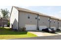 Townhome rear exterior with garages, driveway parking, and small yard at 2692 Pearl Ridge Trce, Buford, GA 30519