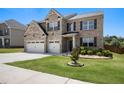 Beautiful two-story home featuring a lush green lawn and an attached two-car garage at 320 Conley Ave, Hampton, GA 30228