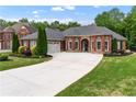 Beautiful brick home featuring a well-manicured lawn, and a large driveway at 1610 Turtle Pond Dr, Hoschton, GA 30548