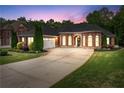 Exterior view of a brick home at dusk featuring a well-manicured lawn, and a large driveway at 1610 Turtle Pond Dr, Hoschton, GA 30548