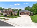 Beautiful brick home featuring a well-manicured lawn, and a large driveway at 1610 Turtle Pond Dr, Hoschton, GA 30548