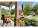 Inviting front porch with chairs and an American flag at 1955 Piedmont Cove Ln, Cumming, GA 30040