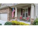 Cozy front porch with stone columns, seating, and decorative plants at 1955 Piedmont Cove Ln, Cumming, GA 30040