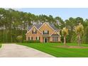 Attractive two-story home boasting manicured lawn and mature trees, blending brick and wood siding for a welcoming curb appeal at 3 Tiffany Trce, Palmetto, GA 30268