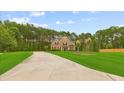 Inviting two-story home with a long driveway, expansive lawn, and mature trees, offering a blend of comfort and classic style at 3 Tiffany Trce, Palmetto, GA 30268