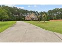 Inviting home with a long driveway leading to a manicured front lawn and trees at 3 Tiffany Trce, Palmetto, GA 30268