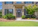 Inviting front entrance with well-maintained landscaping and charming front door at 3179 Falls Crest Ct, Buford, GA 30519