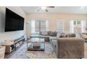 Spacious living room featuring a large sectional sofa, TV, and large windows at 450 Rockfern Ct, Lilburn, GA 30047