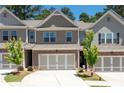 Townhome with brick facade, a two-car garage, and fresh landscaping at 213 Yellowwood Way, Woodstock, GA 30188