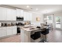 Bright kitchen featuring an island with seating, stainless appliances, and eat in nook with lots of natural light at 213 Yellowwood Way, Woodstock, GA 30188