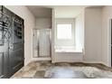 Bright bathroom showcasing a soaking tub, glass-enclosed shower, and neutral tile flooring at 64 Citadel Dr, Hampton, GA 30228