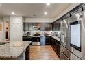 Modern kitchen equipped with stainless steel appliances, dark cabinets and a granite countertop island at 64 Citadel Dr, Hampton, GA 30228