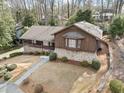 Aerial view of this home showcasing the stone and wood exterior with mature landscaping at 1905 Castleway Ne Ln, Atlanta, GA 30345