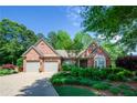 Beautiful brick home with a two-car garage and lush landscaping, offering great curb appeal at 1460 Badingham Dr, Cumming, GA 30041
