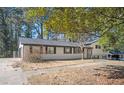 Side view of a well-maintained ranch home showcasing the attached garage and the charming brick exterior with black shutters at 1887 King Charles Sw Rd, Atlanta, GA 30331