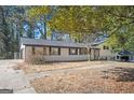 A charming one-story home with white brick, dark shutters, and a well-manicured front yard at 1887 King Charles Sw Rd, Atlanta, GA 30331