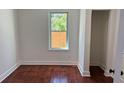 Cozy bedroom features hardwood floors, neutral walls, and a window that overlooks the backyard at 5510 Mason Rd, Atlanta, GA 30349