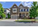 Charming two-story home featuring a covered porch, attached garage and manicured lawn at 828 Olmsted Ln, Duluth, GA 30097