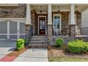 Inviting front porch with rocking chairs, brickwork and manicured landscaping at 828 Olmsted Ln, Duluth, GA 30097