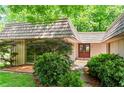 Attractive front entrance featuring a red double door, wood deck, mature landscaping, and unique roofline at 1075 Winding Branch Ln, Atlanta, GA 30338