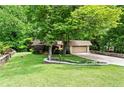 Landscaped front yard features stone walls, healthy lawn, and trees surrounding the home and two car garage at 1075 Winding Branch Ln, Atlanta, GA 30338
