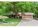 Lovely front yard with mature landscaping, stone retaining wall, and a cozy home with a two-car garage at 1075 Winding Branch Ln, Atlanta, GA 30338