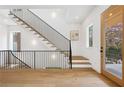 Entryway features light wood floors, a modern black metal staircase, and a view of the outdoors at 1287 Star Ne Dr, Brookhaven, GA 30319