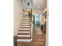 Bright foyer with hardwood floors, staircase with wood and white risers and an accent rug at 150 Holden Way, Woodstock, GA 30189