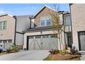 Attractive townhome with gray two-car garage and brick accents, enhancing its street appeal at 2440 Rocky City Ln, Snellville, GA 30078