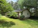Single-story home featuring mature trees and a well-maintained lawn at 108 Fair Oaks Se Dr, Conyers, GA 30094