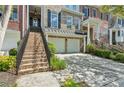 Close-up exterior view of a townhouse featuring brick stairs and a two-car garage, creating a welcoming entrance at 5882 Riverstone Cir # 15, Atlanta, GA 30339