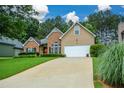 Traditional home with a spacious driveway, brick and siding exterior, manicured landscaping, and a two-car garage at 9013 Aldbury Dr, Locust Grove, GA 30248