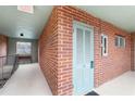 View of an outside condo unit, featuring a numbered door, brick wall, and a well-lit hallway with a bench at 91 Rumson Rd, Atlanta, GA 30305