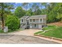 Inviting two-story home with gray siding, white trim, and a spacious front yard with mature trees at 300 Rocky Cove Trl, Lawrenceville, GA 30044