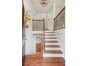 Inviting foyer features hardwood floors, a staircase with decorative iron railings, and a stylish light fixture at 300 Rocky Cove Trl, Lawrenceville, GA 30044